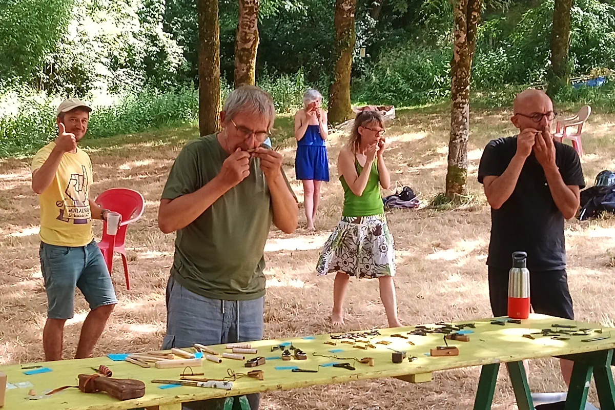 Participants jouant ensemble de la guimbarde pendant un stage en plein air.